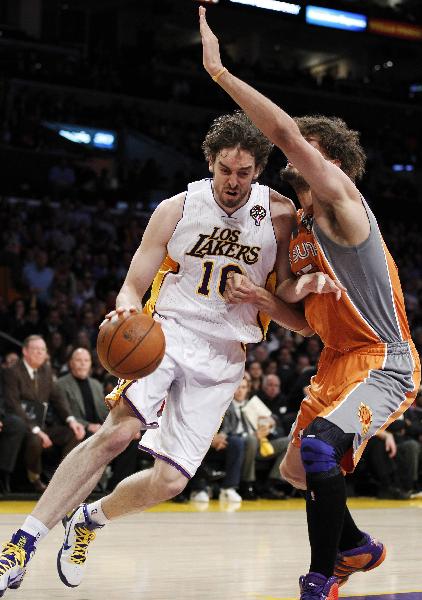 Los Angeles Lakers' Pau Gasol of Spain (L) drives past Phoenix Suns' Robin Lopez during the first half of their NBA game in Los Angeles, California March 22, 2011. (Xinhua/Reuters Photo)