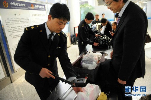 Chinese inspection and quarantine officers conduct radioactive detections for passengers back from Tokyo, Japan on March 16, 2011.