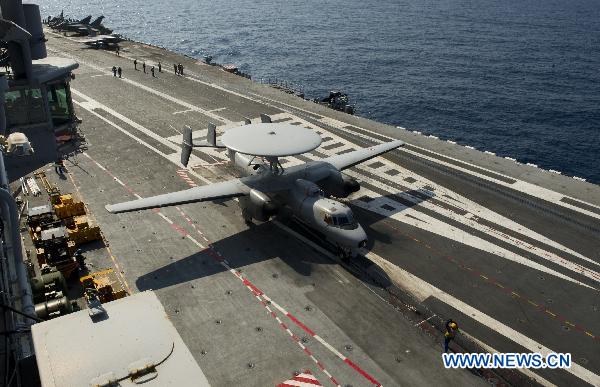 Handout photo released by ECPAD (The French Defence communication and audiovisual production agency) on March 24, 2011 shows crew members prepare prepar Rafale fighter jets for mission aboard the Charles de Gaulle aircraft carrier on March 23, 2011. [Xinhua/ECPAD]