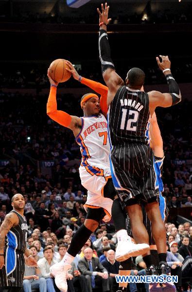 Carmelo Anthony(top L) of New York Knicks passes the ball during their NBA basketball game against Orlando Magic in New York, the United States, March 23, 2011. New York Knicks lost by 99-111. (Xinhua/Shen Hong)