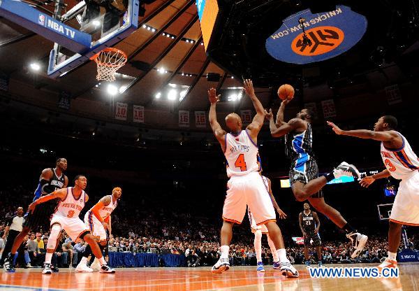 Brandon Bass(2nd R) of Orlando Magic shoots during their NBA basketball game against New York Knicks in New York, the United States, March 23, 2011. New York Knicks lost by 99-111. (Xinhua/Shen Hong) 