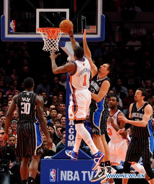 Amar'e Stoudemire(top L) of New York Knicks goes up to the basket during their NBA basketball game against Orlando Magic in New York, the United States, March 23, 2011. New York Knicks lost by 99-111. (Xinhua/Shen Hong)