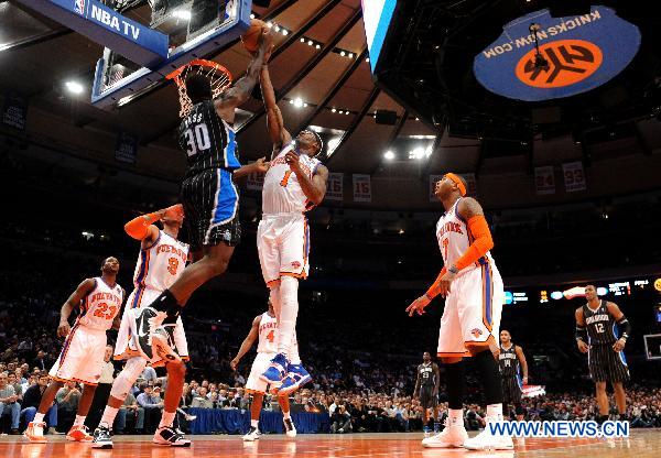 Amar'e Stoudemire(top R) of New York Knicks blocks the shot by Brandon Bass(top L) of Orlando Magic during their NBA basketball game in New York, the United States, March 23, 2011. New York Knicks lost by 99-111. (Xinhua/Shen Hong) 