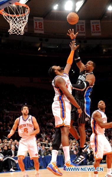 Dwight Howard(top R) of Orlando Magic shoots during their NBA basketball game against New York Knicks in New York, the United States, March 23, 2011. New York Knicks lost by 99-111. (Xinhua/Shen Hong)