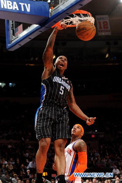 Quentin Richardson (top) of Orlando Magic slam dunks during their NBA basketball game against New York Knicks in New York, the United States, March 23, 2011. New York Knicks lost by 99-111. (Xinhua/Shen Hong)