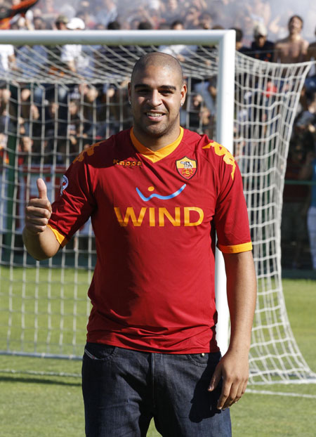 AS Roma's newly signed member Adriano of Brazil poses with a team jersey at the end of a news conference for his presentation at the Flaminio stadium in Rome June 9, 2010. (Xinhua/Reuters File Photo)