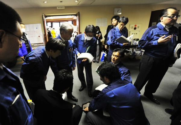 Staff members of Tokyo Electric Power Co. (TEPCO) discuss about strategies at the disaster countermeasures unit in Fukushima City, Japan, March 25, 2011. [Huang Xiaoyong/Xinhua]