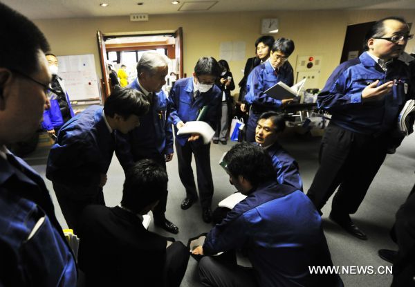 Staff members of Tokyo Electric Power Co. (TEPCO) discuss about strategies at the disaster countermeasures unit in Fukushima City, Japan, March 25, 2011. The city has been witnessing a change of people&apos;s life since the nuclear crisis broke out at the the crippled Fukushima Daiichi nuclear power plant after the earthquake. .[Huang Xiaoyong/Xinhua]