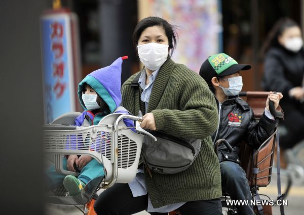 A woman walks on the street with her kids in Fukushima City, Japan, March 25, 2011. The city has been witnessing a change of people&apos;s life since the nuclear crisis broke out at the the crippled Fukushima Daiichi nuclear power plant after the earthquake. [Huang Xiaoyong/Xinhua]