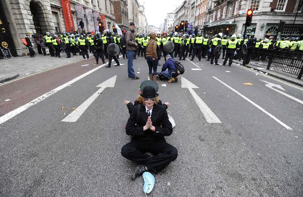 Demonstrators sit down on Piccadilly during a protest organised by the Trades Union Congress (TUC), called 'The March for the Alternative,' in central London March 26, 2011. (Xinhua/Reuters Photo)