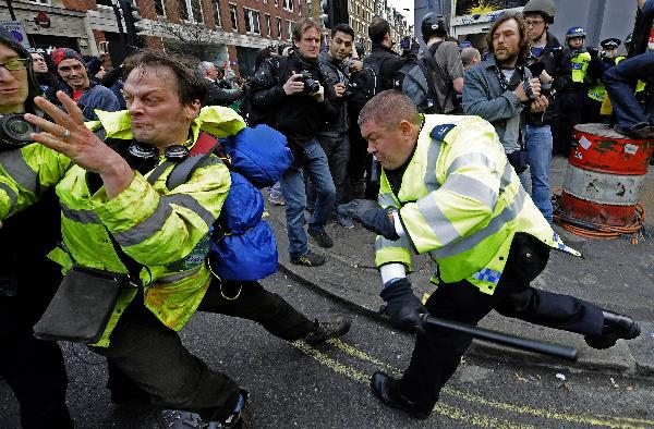 Demonstrators clash with British police officers as they try to storm a department store during a protest against the coalition government's spending cuts, in central London, Saturday, March 26, 2011. (Xinhua/AFP Photo)