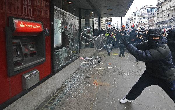 A protester smashES an ATM during a mass demonstration against government financial cuts, in central London, on March 26, 2011. (Xinhua/AFP Photo)