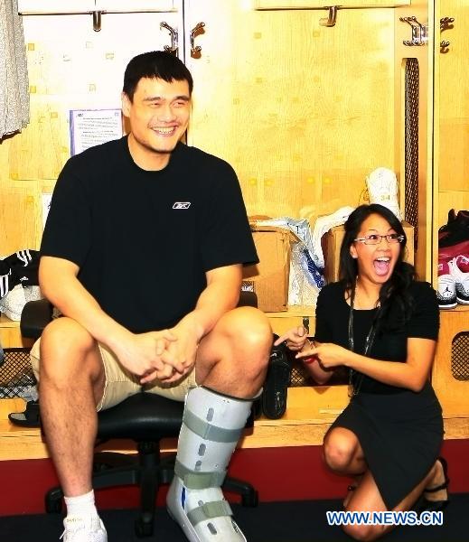 Houston Rockets' player Yao Ming (L) poses with a fan in the dressing room during an event to appreciate the fans' support, in Houston, the United States, March 24, 2011. (Xinhua/Song Qiong) 