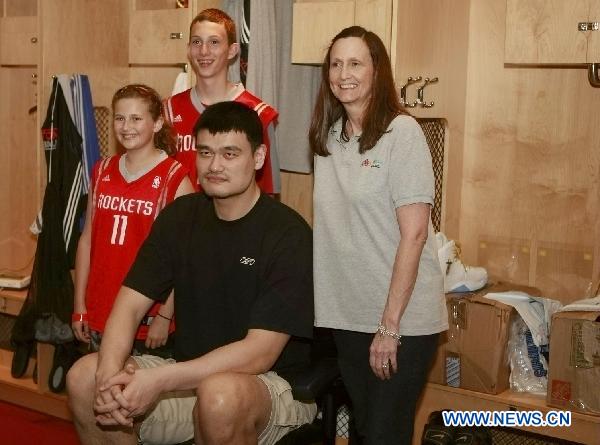 Houston Rockets' player Yao Ming (2rd, R) poses with fans in the dressing room during an event to appreciate the fans' support, in Houston, the United States, March 24, 2011. (Xinhua/Song Qiong) 