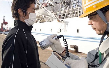 A member of the 'Fukushima 50' emergency crew is given a radiation check.