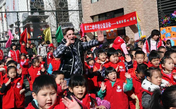A Swedish student (C) practises Chinese martial art during an international folk games festival in a kindergarten in Beijing, capital of China, March 24, 2011. Over ten Swedish middle school students joined the festival to experience Chinese traditional games with the children and teachers of the kindergarten.