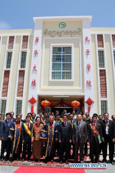 Cambodian Deputy Prime Minister Sok An (4th R, front), who is also minister of the Council of Ministers, and Chinese Ambassador to Cambodia Pan Guangxue (3rd R, front) pose for photos during the inauguration ceremony of a new teaching building of the Confucius Institute of the Royal Academy of Cambodia, in Phnom Penh, Cambodia, March 28, 2011.