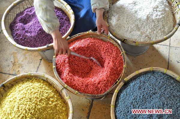 A retailer makes five-color glutinous rice in Nanning, capital of southwest China's Guangxi Zhuang Autonomous Region, March 27, 2011. People of Zhuang ethnic group have a tradition of making five-color glutinous rice during the Qingming Festival, also known as Tomb Sweeping Festival that falls on April 5 this year. Colored by steeped natural herbaceous plants such as day lily and maple leaf, the five-color rice, represents a good harvest of the year. [Xinhua]