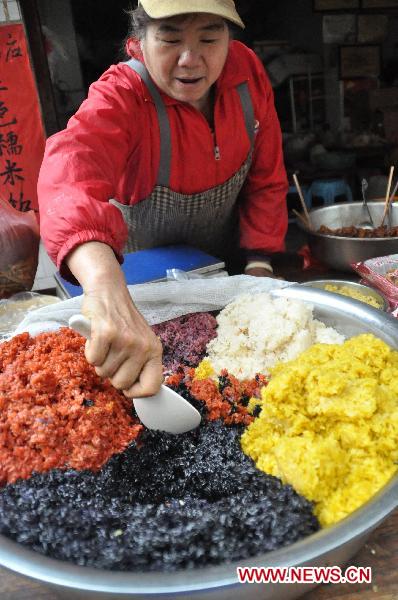 A retailer makes five-color glutinous rice in Nanning, capital of southwest China's Guangxi Zhuang Autonomous Region, March 27, 2011. [Xinhua]