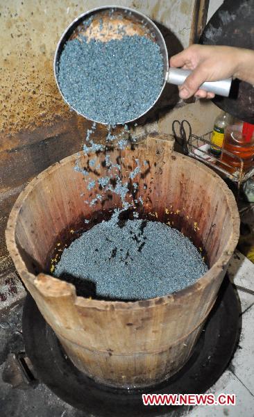 A retailer makes five-color glutinous rice in Nanning, capital of southwest China's Guangxi Zhuang Autonomous Region, March 27, 2011. [Xinhua]