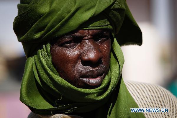 An African migrant is seen at the Egyptian border crossing of Sallum, March 29, 2011. Thousands of refugees have gathered near the border of Libya and Egypt to flee the violence in Libya and wait for the help from international organizations.[Cai Yang/Xinhua]