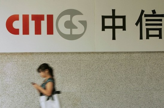 A woman passes the logo of CITIC Securities at a branch of the security brokerage house in Shanghai.The company could raise about $2.8 billion if it can sell H shares at a premium over its mainland-listed A shares.