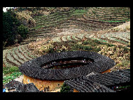 Photo shows the Tianluokeng Tulou, earth buildings in Chinese, in Nanjing County, southeast China's Fujian Province. Built on a base of stone, the thick walls of Tulou were packed with dirt and fortified with wood or bamboo internally. The architectural arts of the Fujian Tulou can be traced back nearly 1,000 years, and their design incorporates the tradition of fengshui (favorable siting within the environment). [老人河  /forums.nphoto.net]