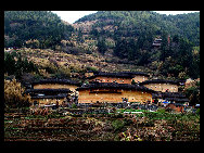 Photo shows the Tianluokeng Tulou, earth buildings in Chinese, in Nanjing County, southeast China's Fujian Province. Built on a base of stone, the thick walls of Tulou were packed with dirt and fortified with wood or bamboo internally. The architectural arts of the Fujian Tulou can be traced back nearly 1,000 years, and their design incorporates the tradition of fengshui (favorable siting within the environment). [老人河  /forums.nphoto.net]