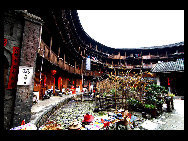 Photo shows the Tianluokeng Tulou, earth buildings in Chinese, in Nanjing County, southeast China's Fujian Province. Built on a base of stone, the thick walls of Tulou were packed with dirt and fortified with wood or bamboo internally. The architectural arts of the Fujian Tulou can be traced back nearly 1,000 years, and their design incorporates the tradition of fengshui (favorable siting within the environment). [老人河  /forums.nphoto.net]