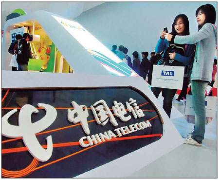 Visitors take photos in front of the China Telecommunications Corporation booth at a telecom exhibition in Shanghai this year. The number of subscribers using the company's mobile services has risen to more than 100 million. [China Daily]