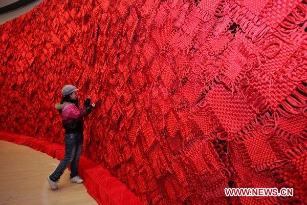 A visitor touches a Chinese knot at the National Art Museum of China (NAMOC), Jan. 9, 2011. [Xinhua]