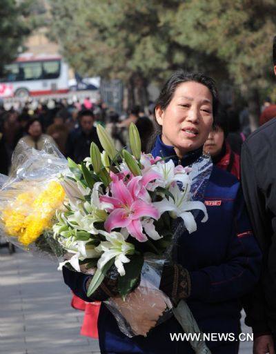 A woman is seen holding a bunch of flowers in a cemetery in Beijing, capital of China, March 26, 2011, a few days ahead of China's traditional tomb-sweeping day on which Chinese memorized their beloved ones, on April 5th this year. (Xinhua/Li Wen) (cxy) 