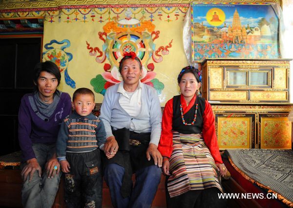 Pudawa and his family pose for photo in the dining hall, in Lnaze County of Xigaze Prefecture, southwest China's Tibet Autonomous Region, March 31, 2011. For 54-year-old craftsman Pudawa, inheritor of the Lnaze knife craftsmanship, nothing is happier than seeing his son Doje Zhamdu making better knife than his own. 'That means the craftsmanship of my family would pass onto the next generation. I am quite released. ' said the old Tibetan man. The Lnaze County, located at a remote region of Xigaze on the Qinghai-Tibet Plateau, is known for rich folk arts, such as the Tibetan tap dance and hand-made Tibetan knife. In 2008, the craftsmanship of Tibetan knife making in Lnaze County has been listed into China's National Intangible Cultural Heritages. Pudawa, being the sixth generation of a blacksmith family, is the most famous knife maker in the town. His knives always fail to meet growing demand as many Tibetans and tourists flock to his door asking for knives. Ten years ago, his son Doje Zhamdu began to learn the family skills. From the age of 18, he sat side by side with Pudawa, copying every step his father did, remembering all procedures in mind. Today he has become a knife maker as excellent as his father. However, he was quite reluctant to be a blacksmith at first. Like many young men in the town, he yearned for going outside as a migrant worker. 'In the old concept of Tibetans, blacksmith is a low-class career and not respected. People call us 'black bones'. ' said the son. But at last, the young man submitted to his father's wish to inherit the skills. Nowadays, with an annual family income of 26,000 yuan, much higher than the average, Doje felt happy about his choice. 'I am the eldest child in my family. I have to shoulder the responsibility to pass on the skills. Moreover, working at home with my father is convenient for taking care of the whole family.' Besides father and son, women also shoulder important responsibility in this family. Yexe Zhoima, the second daughter of Pudawa, weaves pulu, a traditional Tibetan-featured haircloth, at home, while Cering Quzhen, the elder daughter with blindness, studies at a government-funded special school in Lhasa. According to the Tibetan tradition, the family's craftsmanship can only pass on to male kin. Yixi Zhuoma likes watching her father and brother forging knives, but the only job she can do is cleaning the finished ones. 'I am proud of them.' She said with a smile while weaving pulu, which also brings a monthly income of 1,500 to the family. Though having a comfortable life and famous among people, Pudawa still has worries. The repute of Lnaze knife is now under great impact of massive machine-made knives sold on the market. As it takes a craftsman two to three days to forge a small-sized knife, even direct orders cannot be satisfied. In contrast, machine-made knives can be produced faster. 'I hope more people know about Lnaze knife and more young men learn the skills. Then people will not confuse real handmade knives with the fake ones,' said Pudawa, 'then I can truly retire from work and enjoy the rest of my life.' (Xinhua/Xu Yu) 