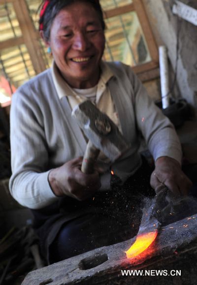 Pudawa forges a knife edge in his workshop at home, in Lnaze County of Xigaze Prefecture, southwest China's Tibet Autonomous Region, March 31, 2011. For 54-year-old craftsman Pudawa, inheritor of the Lnaze knife craftsmanship, nothing is happier than seeing his son Doje Zhamdu making better knife than his own. 'That means the craftsmanship of my family would pass onto the next generation. I am quite released. ' said the old Tibetan man. The Lnaze County, located at a remote region of Xigaze on the Qinghai-Tibet Plateau, is known for rich folk arts, such as the Tibetan tap dance and hand-made Tibetan knife. In 2008, the craftsmanship of Tibetan knife making in Lnaze County has been listed into China's National Intangible Cultural Heritages. Pudawa, being the sixth generation of a blacksmith family, is the most famous knife maker in the town. His knives always fail to meet growing demand as many Tibetans and tourists flock to his door asking for knives. Ten years ago, his son Doje Zhamdu began to learn the family skills. From the age of 18, he sat side by side with Pudawa, copying every step his father did, remembering all procedures in mind. Today he has become a knife maker as excellent as his father. However, he was quite reluctant to be a blacksmith at first. Like many young men in the town, he yearned for going outside as a migrant worker. 'In the old concept of Tibetans, blacksmith is a low-class career and not respected. People call us 'black bones'. ' said the son. But at last, the young man submitted to his father's wish to inherit the skills. Nowadays, with an annual family income of 26,000 yuan, much higher than the average, Doje felt happy about his choice. 'I am the eldest child in my family. I have to shoulder the responsibility to pass on the skills. Moreover, working at home with my father is convenient for taking care of the whole family.' Besides father and son, women also shoulder important responsibility in this family. Yexe Zhoima, the second daughter of Pudawa, weaves pulu, a traditional Tibetan-featured haircloth, at home, while Cering Quzhen, the elder daughter with blindness, studies at a government-funded special school in Lhasa. According to the Tibetan tradition, the family's craftsmanship can only pass on to male kin. Yixi Zhuoma likes watching her father and brother forging knives, but the only job she can do is cleaning the finished ones. 'I am proud of them.' She said with a smile while weaving pulu, which also brings a monthly income of 1,500 to the family. Though having a comfortable life and famous among people, Pudawa still has worries. The repute of Lnaze knife is now under great impact of massive machine-made knives sold on the market. As it takes a craftsman two to three days to forge a small-sized knife, even direct orders cannot be satisfied. In contrast, machine-made knives can be produced faster. 'I hope more people know about Lnaze knife and more young men learn the skills. Then people will not confuse real handmade knives with the fake ones,' said Pudawa, 'then I can truly retire from work and enjoy the rest of my life.' (Xinhua/Tao Xiyi) 