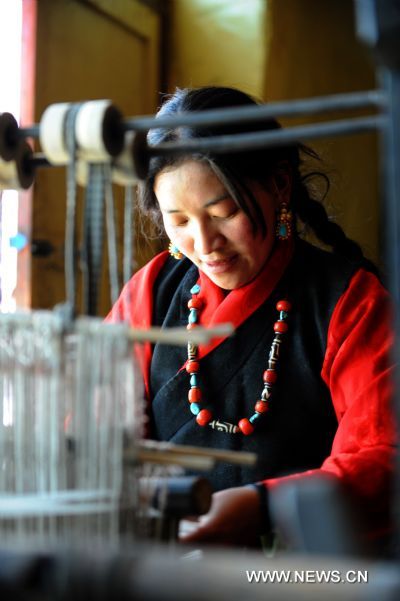 Yexe Zhoima weaves pulu at home in Lnaze County of Xigaze Prefecture, southwest China's Tibet Autonomous Region, March 31, 2011. For 54-year-old craftsman Pudawa, inheritor of the Lnaze knife craftsmanship, nothing is happier than seeing his son Doje Zhamdu making better knife than his own. 'That means the craftsmanship of my family would pass onto the next generation. I am quite released. ' said the old Tibetan man. The Lnaze County, located at a remote region of Xigaze on the Qinghai-Tibet Plateau, is known for rich folk arts, such as the Tibetan tap dance and hand-made Tibetan knife. In 2008, the craftsmanship of Tibetan knife making in Lnaze County has been listed into China's National Intangible Cultural Heritages. Pudawa, being the sixth generation of a blacksmith family, is the most famous knife maker in the town. His knives always fail to meet growing demand as many Tibetans and tourists flock to his door asking for knives. Ten years ago, his son Doje Zhamdu began to learn the family skills. From the age of 18, he sat side by side with Pudawa, copying every step his father did, remembering all procedures in mind. Today he has become a knife maker as excellent as his father. However, he was quite reluctant to be a blacksmith at first. Like many young men in the town, he yearned for going outside as a migrant worker. 'In the old concept of Tibetans, blacksmith is a low-class career and not respected. People call us 'black bones'. ' said the son. But at last, the young man submitted to his father's wish to inherit the skills. Nowadays, with an annual family income of 26,000 yuan, much higher than the average, Doje felt happy about his choice. 'I am the eldest child in my family. I have to shoulder the responsibility to pass on the skills. Moreover, working at home with my father is convenient for taking care of the whole family.' Besides father and son, women also shoulder important responsibility in this family. Yexe Zhoima, the second daughter of Pudawa, weaves pulu, a traditional Tibetan-featured haircloth, at home, while Cering Quzhen, the elder daughter with blindness, studies at a government-funded special school in Lhasa. According to the Tibetan tradition, the family's craftsmanship can only pass on to male kin. Yixi Zhuoma likes watching her father and brother forging knives, but the only job she can do is cleaning the finished ones. 'I am proud of them.' She said with a smile while weaving pulu, which also brings a monthly income of 1,500 to the family. Though having a comfortable life and famous among people, Pudawa still has worries. The repute of Lnaze knife is now under great impact of massive machine-made knives sold on the market. As it takes a craftsman two to three days to forge a small-sized knife, even direct orders cannot be satisfied. In contrast, machine-made knives can be produced faster. 'I hope more people know about Lnaze knife and more young men learn the skills. Then people will not confuse real handmade knives with the fake ones,' said Pudawa, 'then I can truly retire from work and enjoy the rest of my life.' (Xinhua/Zou Guangping) 