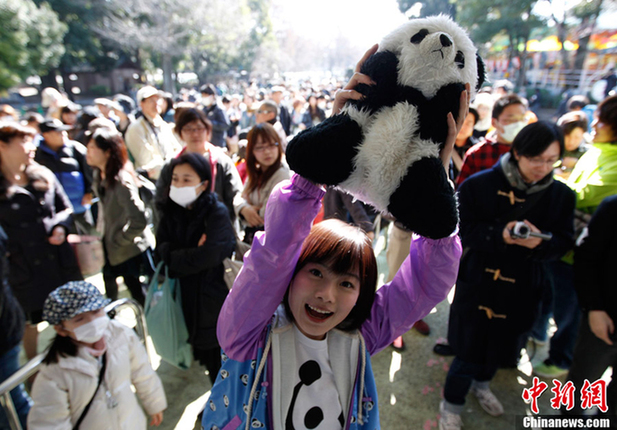 Crowds of people wait outside the gate of Ueno Zoo in Tokyo to visit China's giant pandas, female panda Xian Nu and male Bi Li, in Japan, April 1, 2011.