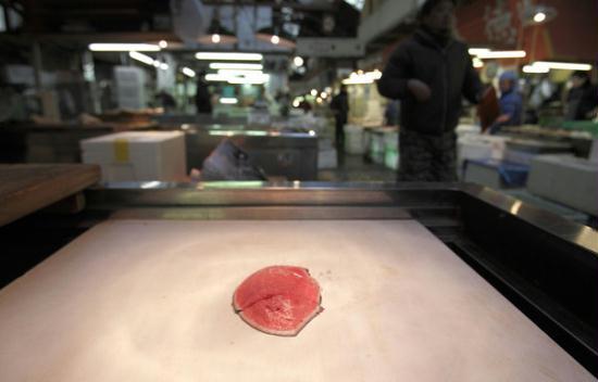 a lone piece of tuna sits at a stall in the tsukiji fish market saturday, march 19, 2011, in tokyo. one of the world's largest fish markets, the tsukiji fish market has seen a slowdown in its normally bustling pace as distribution system was shattered following the march 11 2011 tsunami triggered by earthquake. 