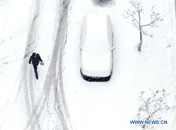 A Pedestrians walks on a snow-covered path in a residential area in downtown Urumqi, capital of northwest China&apos;s Xinjiang Uygur Autonomous Region, April 4, 2011. A heavy snow hit Urumqi Monday, where the temperature dropped to six degrees Celsius under zero. [Xinhua]