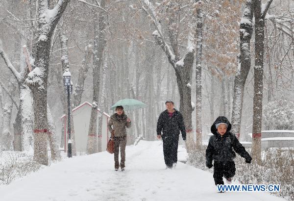 Pedestrians walk on a snow-covered street in downtown Urumqi, capital of northwest China&apos;s Xinjiang Uygur Autonomous Region, April 4, 2011. A heavy snow hit Urumqi Monday, where the temperature dropped to six degrees Celsius under zero. 