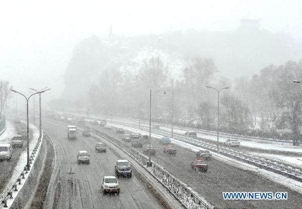 Vehicles move on a main road covered by melting snow in Urumqi, capital of northwest China&apos;s Xinjiang Uygur Autonomous Region, April 4, 2011. A heavy snow hit Urumqi Monday, where the temperature dropped to six degrees Celsius under zero.