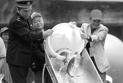 Representatives from fishery authorities in Guangdong province release some of the 3.2 million fish into the Xijiang River, a major tributary to the Pearl River, on April 1. [China Daily] 