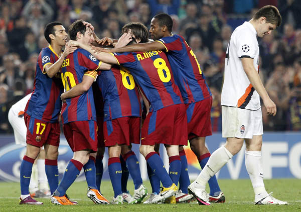 Barcelona's players celebrate their team's fifth goal past Shakhtar Donetsk's Yaroslav Rakitskiy during the first leg of their Champions League quarter-final soccer match at Camp Nou stadium in Barcelona April 6, 2011. (Xinhua/Reuters Photo)