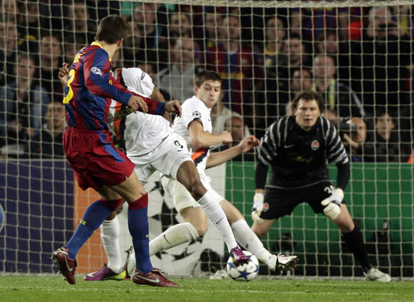 Barcelona's Gerard Pique (L) shoots to score against Shakhtar Donetsk during the first leg of their Champions League quarter-final soccer match at Camp Nou stadium in Barcelona April 6, 2011. (Xinhua/Reuters Photo)