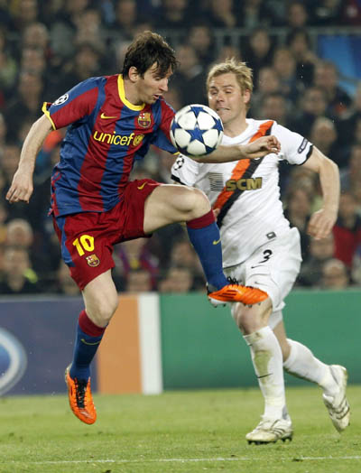 Barcelona's Lionel Messi (L) controls the ball beside Shakhtar Donetsk's Tomas Hubschman during the first leg of their Champions League quarter-final soccer match at Camp Nou stadium in Barcelona April 6, 2011. (Xinhua/Reuters Photo)