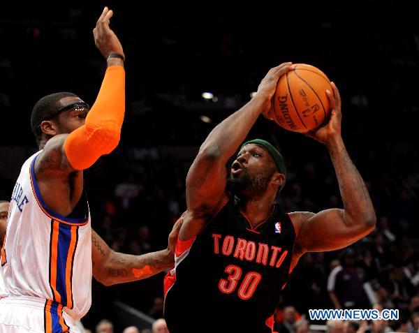 Reggie Evans (R) of Toronto Raptors controls the ball during the NBA game against New York Knicks in New York, the United States, April 5, 2011. New York Knicks won 131-118. (Xinhua/Shen Hong)