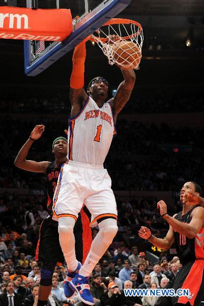 Amar'e Stoudemire (top) of New York Knicks dunks during the NBA game against Toronto Raptors in New York, the United States, April 5, 2011. New York Knicks won 131-118. (Xinhua/Shen Hong)