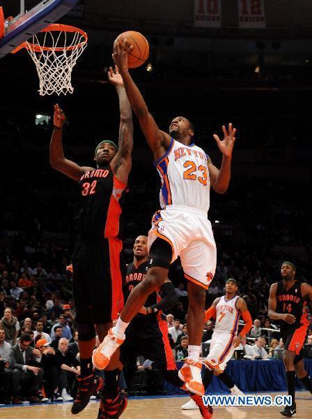 Toney Douglas (top R) of New York Knicks goes up for a shot during the NBA game against Toronto Raptors in New York, the United States, April 5, 2011. New York Knicks won 131-118. (Xinhua/Shen Hong) 