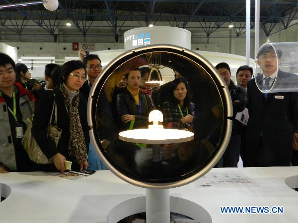 Visitors look at a type of illuminative product at the 2011 illumination exhibition in Beijing, China, April 6, 2011. The three-day illumination exhibition opened here Wednesday, featuring low-carbon and energy saving products. [Xinhua] 