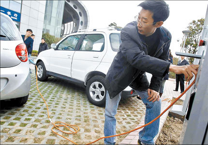 No fuel price rise worry for this driver as he charges his electric car yesterday when eight electric cars owned by individuals officially hit the road in the city as Shanghai expanded the use of greener transport to private consumers. [Shanghai Daily]