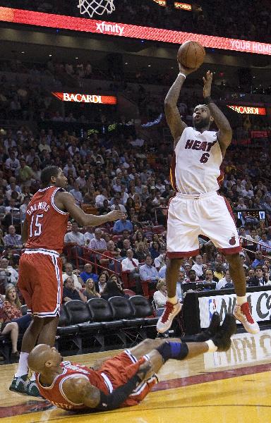 The Miami Heat's Forward Lebron James shoots over the Milwaukee Bucks' Forward Corey Maggette, as Bucks' Guard John Salmons (L) looks on, in the first half of their NBA basketball game in Miami, Florida April 6, 2011. (Xinhua/Reuters Photo)